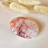 Fire quartz palmstone, oval polished pink stone with red veining.