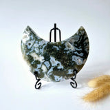 Moss agate crescent moon on black metal stand with druzy pattern