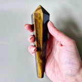 Tiger's eye scepter, 15 cm, polished golden-brown crystal held in hand