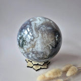 Kristallen Edelsteen mosagaat druzy geode sphere, grijs-wit met drusy kristallen, 120mm diameter op stervormige stand