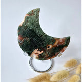 Rode druzy moss agate moon on stand; crescent shape with green moss and red-brown patches, 10–12 cm