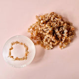 Sunstone Edelsteen Chips Armband; roze‑oranje chips en losse stenen op roze achtergrond
