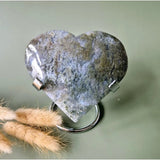 Gray-blue druzy moss agate heart on a metal stand with silver clamps