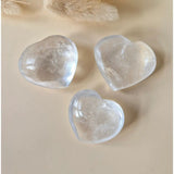 Three clear quartz heart stones, polished, 3–4 cm each