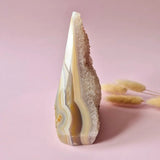 Druzy grijze agaat staande edelsteen met kristalrand en gelaagde pastel banding