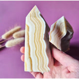 Gele onyx toren met ruwe zijkant, 2 stuks met gele en crèmekleurige banding (150–250 g)