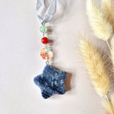 Kerstster edelsteen hanger met blauwe stervormige edelsteen, mintgroene en Rode kralen en iriserende facetdisc.
