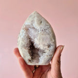 Druzy Roze Amethyst freeform geode crystal, teardrop shape, held in hand