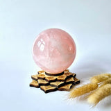 Rose quartz crystal sphere, 90mm, 1kg, on a carved wooden star-shaped display base