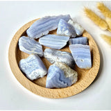 Blue lace agate chunks, polished light-blue banded stones from Moonlight Gemstones on a wooden circular plate