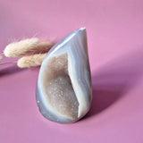 Druzy gray agate teardrop gemstone with blue-gray banding and glittery interior geode