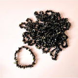 Moonlight Gemstones Golden Obsidian chip bracelet featuring black-gold beads on a soft pink background