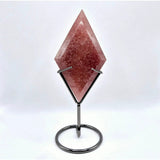 Starry strawberry quartz rhombus-cut gemstone on a metal display stand, pink with natural inclusions