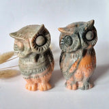Two green onyx owl carvings, calcite onyx sculpture about 10 cm tall, with peach-colored bases, displayed side by side