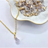 Goudkleurige ketting met ruwe bergkristal hanger van 1 cm aan goudkleurige schakelketen