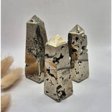 Pyrite obelisk towers, four 8–10 cm crystals with druzy textures and metallic luster.