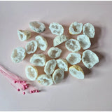 White agate geodes with druzy sparkle, a set of hollow crystal clusters on pink background