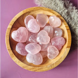 Rose quartz heart stones in a wooden bowl; pink, polished crystals (about a dozen)