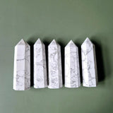Five white howlite obelisk towers with gray veining, 8–10 cm tall.