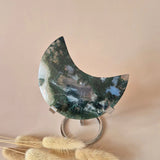 Moss agate crescent moon on metal stand with green drusy patterns, 150g