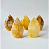 Five Golden Healer teardrop crystals, yellow quartz stones standing upright.