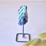 Ruwe edelsteen op metalen standaard, blauw met witte aders, ca. 12 cm hoog