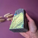 XL purple rainbow labradorite tower with rainbow flash, held in hand