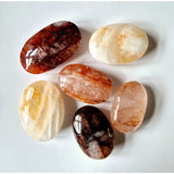 Kristal Vuurkwarts palmstones by Moonlight Gemstones; six polished quartz stones in red, peach, and cream