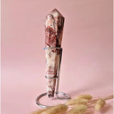 Edelsteen Pork Stone Scepter by Moonlight Gemstones on a metal stand, pink and white banded wand, 15–18 cm