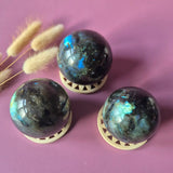 Moonlight Gemstones Labradorite sphere trio, 50–85 mm, features blue flash on display stands