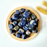 Sodalite palm stones, blue, 2 cm, in a round wooden dish