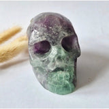 Fluorite gemstone skull sculpture in purple and green hues