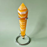 Gele calciet scepter op standaard, geel-oranje banding met witte lagen, op metalen ringvoet, 10–13 cm