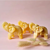 Set of four polished yellow calcite elephant crystal sculptures, each 10–12 cm.