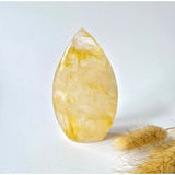 Golden Healer teardrop crystal, standing display, translucent yellow with internal veining