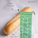 green-goose herbruikbare rPET stokbroodzak 70x21cm met stokbrood naast groene tas; stevige metalen sluiting