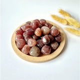 Strawberry quartz trommelstenen in houten schaal; gepolijste roze-rode handstenen, 2 cm