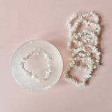 Edelsteen Witte Maansteen Chips Armband van Moonlight Gemstones; witte maansteen chips op roze achtergrond