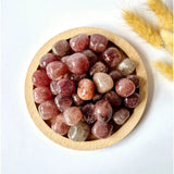Strawberry Quartz tumbled palm stones, pink-red polished 2 cm stones in a wooden bowl