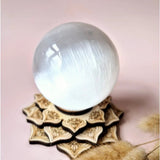 Seleniet kristallen bol 80mm, wit-transparant, Moonlight Gemstones op houten stand