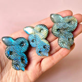 Three labradorite snake carvings with iridescent blue-green scales, 5 cm each