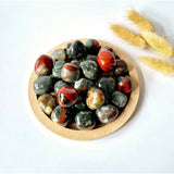 Edelsteen African Bloodstone hand stones by Moonlight Gemstones, 2 cm tumbled red-green beads in a wooden dish