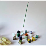 Gemstone cube incense holder, 20mm, with a green incense stick; colorful gemstone cubes scattered.