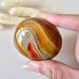 Sardonyx palmsteen van Moonlight Gemstones, gepolijst met warme oranje‑bruine banden, 5–10 cm