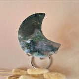 XL moss agate crescent moon on metal stand; green moss patterns with white-gray inclusions.