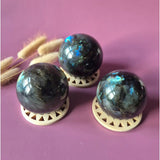 Labradoriet bol – edelsteen sphere met flash, iriserende blauwgroene glans; set van 3 op houten onderzetters.