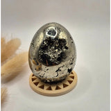 Edelsteen bol Pyriet met druzy kristallen, 40–50 mm, op beige displaystand.