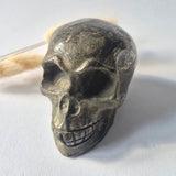 Pyriet Skull, 690 g hand-carved crystal skull in dark gray with metallic veining