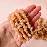 Sunstone edelsteen chips armband met peachkleurige onregelmatige chipjes in hand