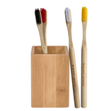 Bamboo toothbrush holder by green-goose with four bamboo toothbrushes (black, red, white, yellow bristles).